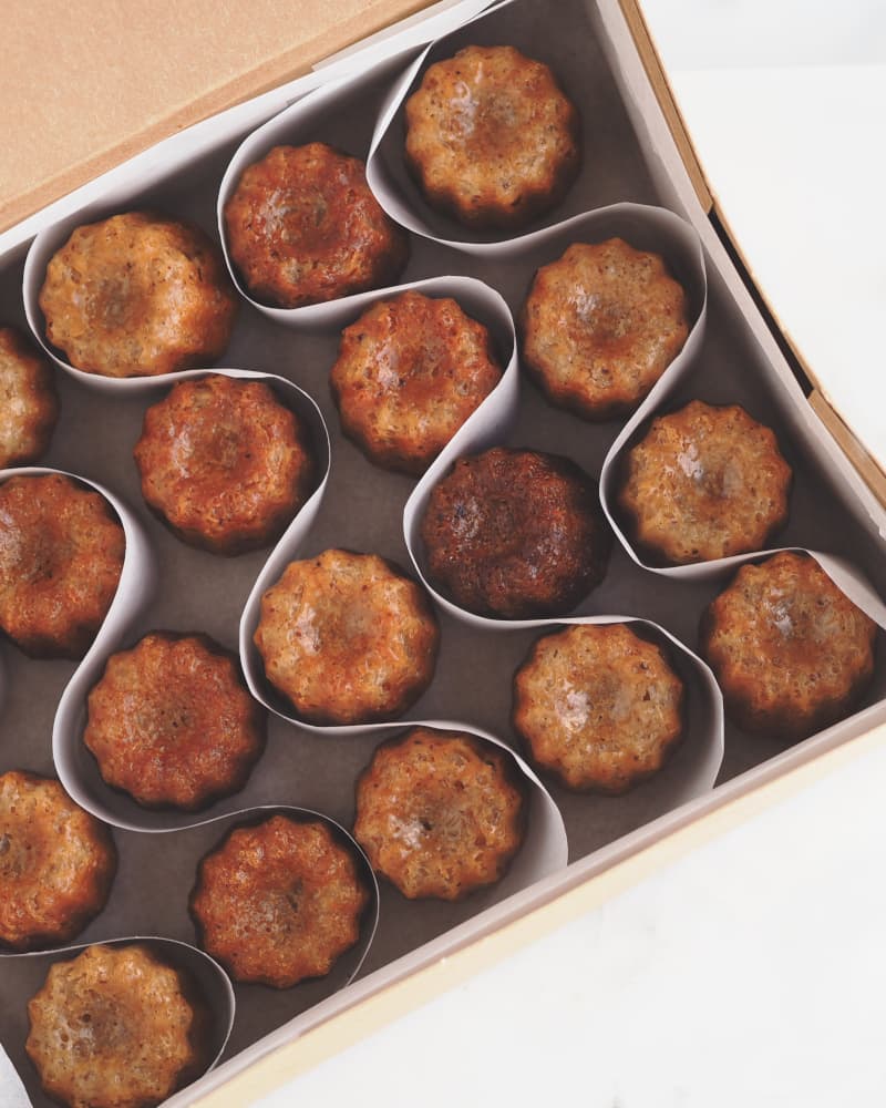 Surtido de mini pasteles veganos y bocaditos tipo cannelé para eventos.